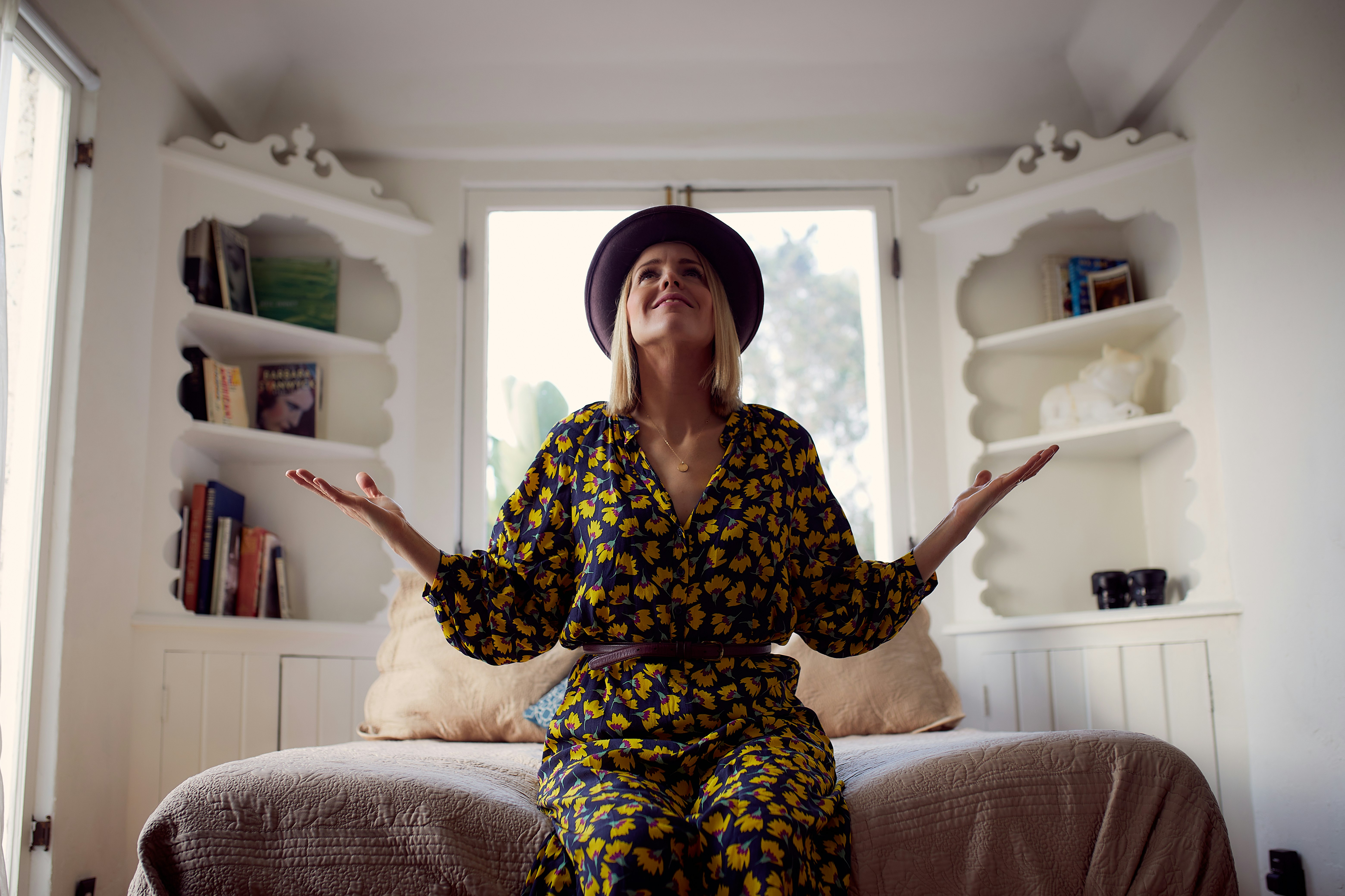 woman in black and white floral dress sitting on white couch